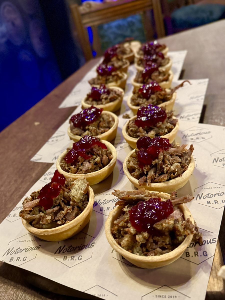 Pastry tarts topped with cranberry, lined up on a board