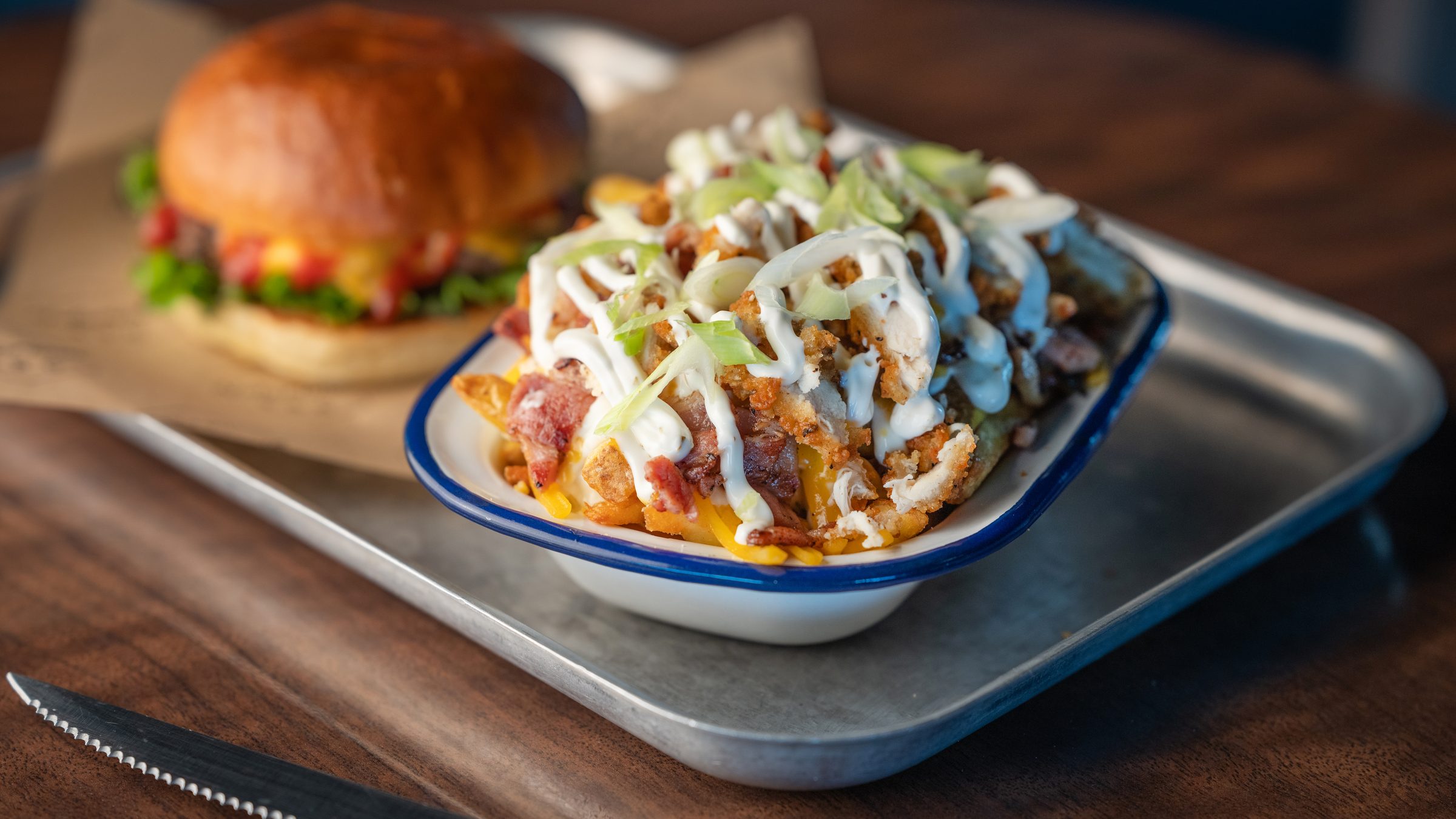 A Notorious BRG burger and chicken and bacon ranch loaded fries on a tray