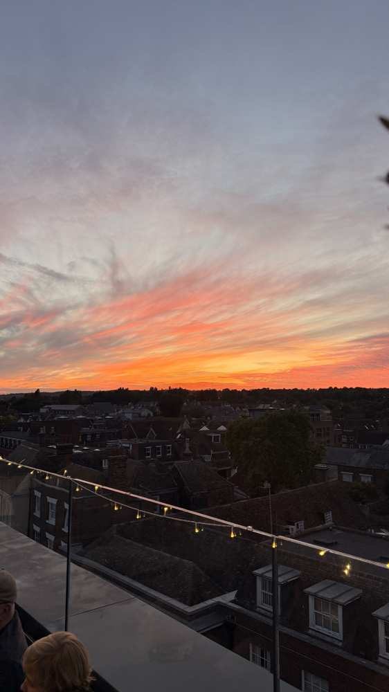 Sunset over Canterbury rooftops from the terrace, festoon lights overhead